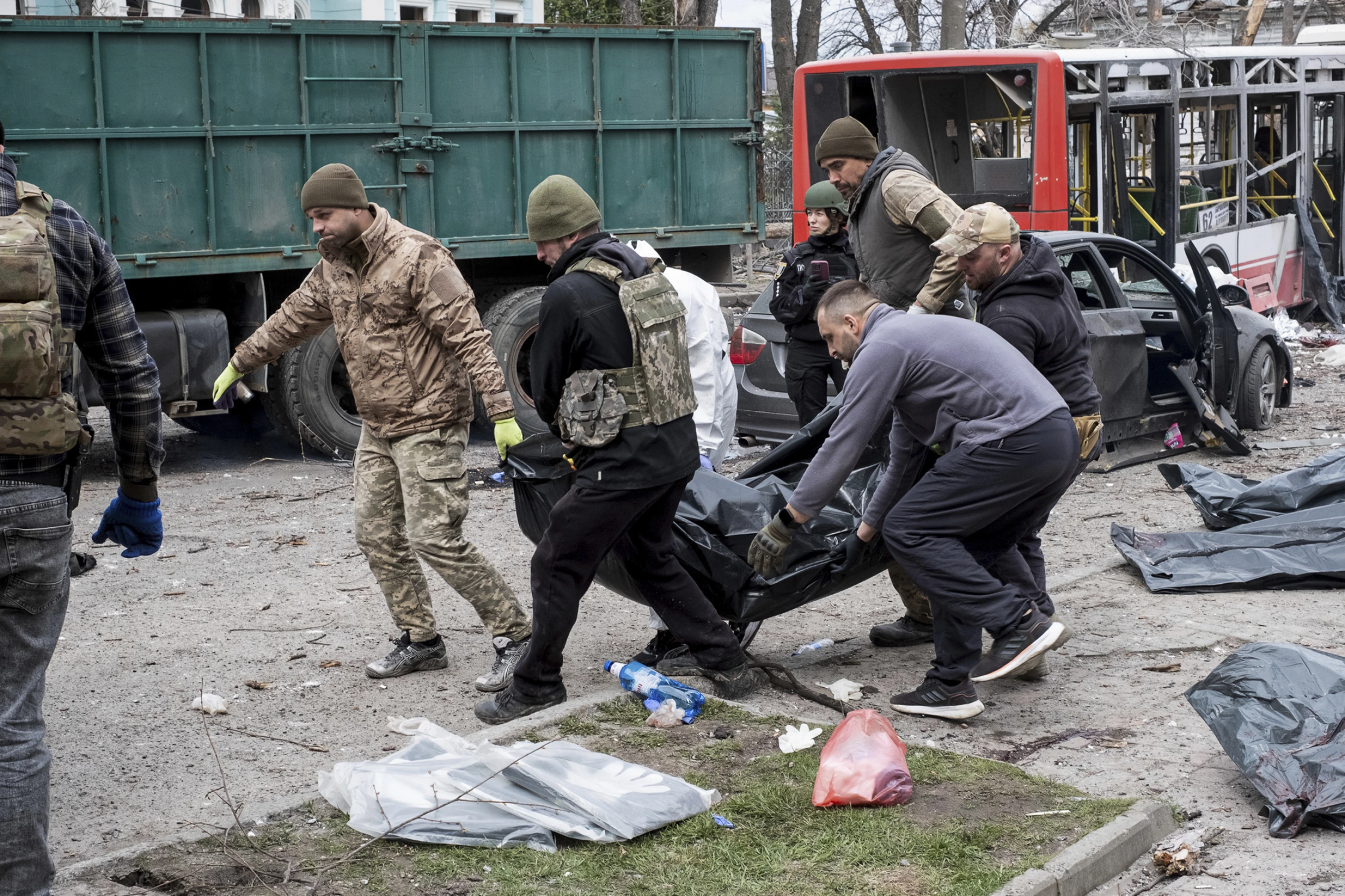 Українські військові несуть тіло мертвого після ракетного удару Росії по Сумах, Україна, неділя, 13 квітня 2025 р.
